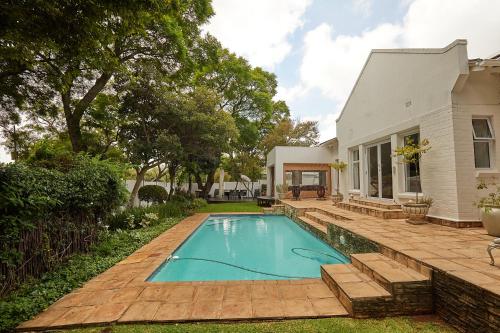 una piscina en el patio trasero de una casa en Maison Jacaranda, en Johannesburgo