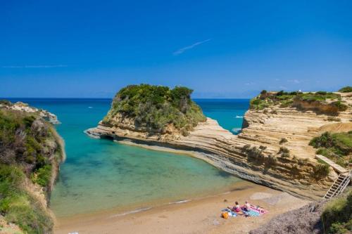 a group of people on a beach between two rocks at Harma Corfu in Sidari
