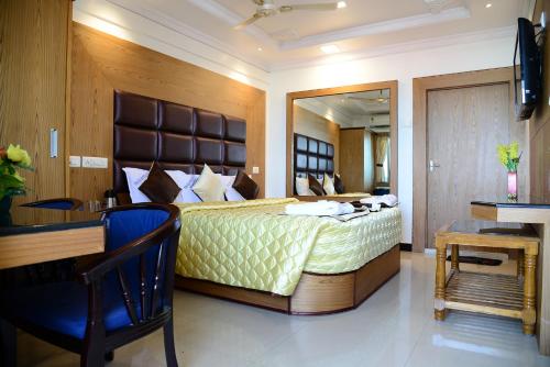 ein Schlafzimmer mit einem Bett und einem Schreibtisch in einem Zimmer in der Unterkunft Hotel Tri Sea in Kanyakumari