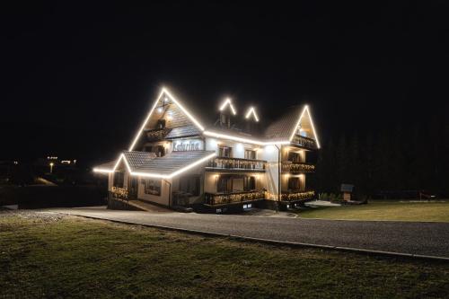 a large house with lights on it at night at Penzion Katarina in Ždiar