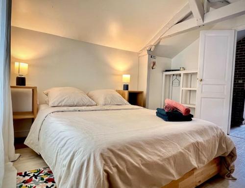 ein Schlafzimmer mit einem großen Bett mit weißer Bettwäsche in der Unterkunft Cosy townhouse near the forest and RER in Saint-Germain-en-Laye