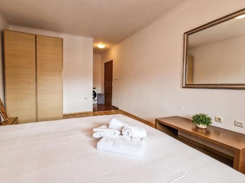 a bedroom with a bed with towels on it at Cedar Lodge 2 Bedroom Apartment by Flat Mаnager in Bansko