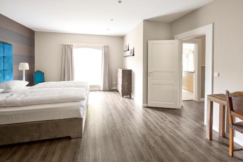 sypialnia z dużym łóżkiem i drewnianą podłogą w obiekcie Landhaus Basthorst w mieście Crivitz