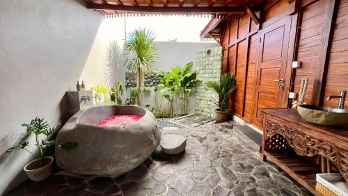 a bathroom with a large tub with plants in it at Jabunami Villa in Canggu