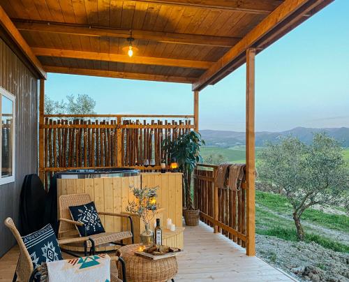 a screened porch with a view of the mountains at Le Fraine - Agriturismo & Olives Glamping in Santa Luce