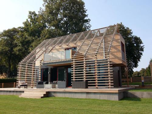 ein großes Holzhaus auf einem Feld gezeigt wird in der Unterkunft Chalet Wendorf in Wendorf