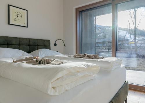 two white beds in a room with a window at DAS GRIES in Schladming