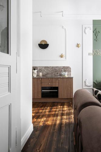a living room with white walls and a wooden floor at Retro Apartamenty in Przemyśl
