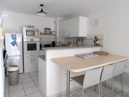 une cuisine avec des armoires blanches et un comptoir en bois dans l'établissement Canet en Roussillon appartement 4 pers proche plage, à Canet