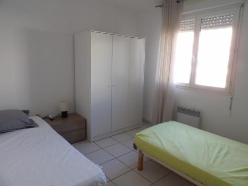 - une chambre avec un lit, une armoire et une fenêtre dans l'établissement Canet en Roussillon appartement 4 pers proche plage, à Canet