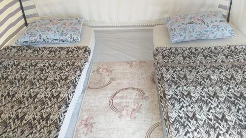 2 camas en una habitación con 2 almohadas en Kardelen Camping, en Muğla