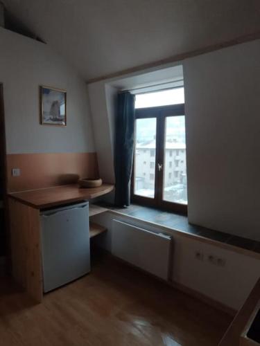 une cuisine avec une fenêtre et un comptoir avec une table dans l'établissement Studio deux personnes, à Briançon