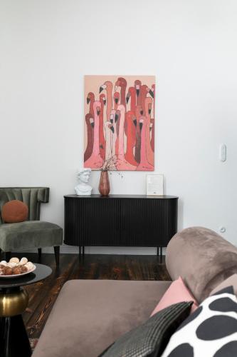 a living room with a couch and a painting on the wall at Retro Apartamenty in Przemyśl