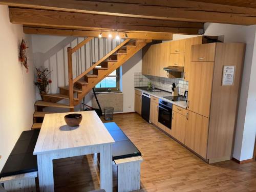 a kitchen with a wooden table and a wooden staircase at Blockhaus im Bayrischen Wald in Hohenau