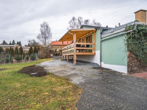 ein Haus mit Holzkonstruktion neben einer Garage in der Unterkunft Modern holiday home with shared swimming pool in Mittelndorf in Mittelndorf
