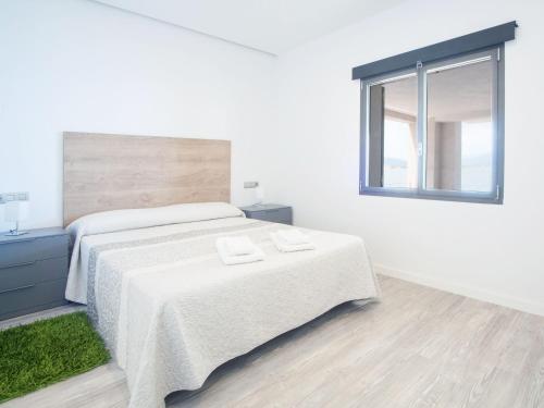 a white bedroom with a bed and a window at Aixa - House In Marina Manresa Free Wifi in Alcudia
