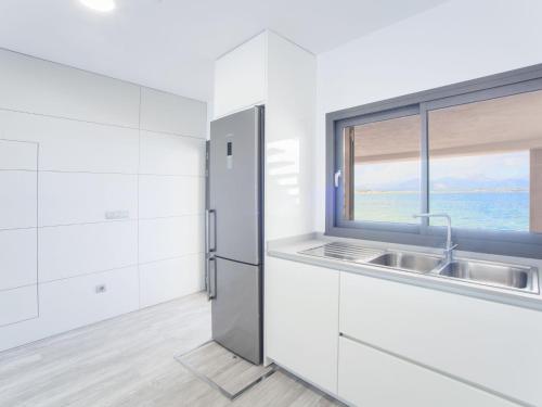 a white kitchen with a sink and a window at Aixa - House In Marina Manresa Free Wifi in Alcudia