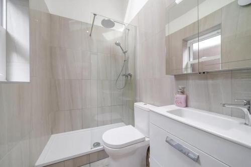 a white bathroom with a toilet and a sink at Charming spacious 2-Bed Apartment in London in London