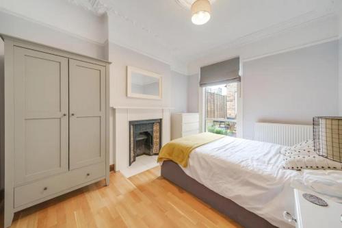 a white bedroom with a bed and a fireplace at Charming spacious 2-Bed Apartment in London in London