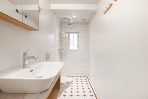 een witte badkamer met een wastafel en een toilet bij Solbjerggaard Studio Apartments in Fåborg