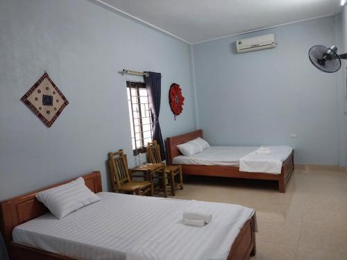 a hotel room with two beds and a window at Tom's House in Hòa Bình