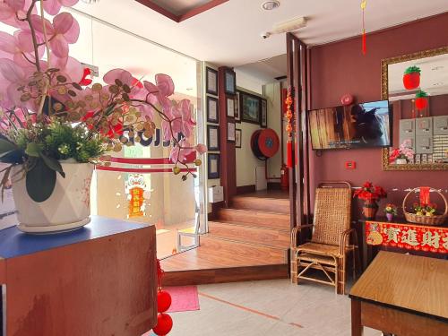 una sala de estar con un jarrón de flores sobre una mesa en OYO 90964 Melody 88 Inn, en Miri