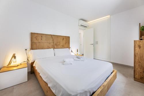 een slaapkamer met een groot bed met een houten hoofdeinde bij Can Perello in Muro