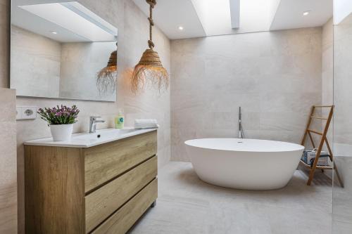 een badkamer met een wit bad en een wastafel bij Can Perello in Muro