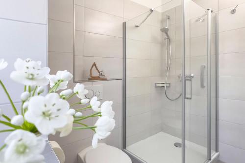 キュールングスボルンにあるHaus Finjaのバスルーム(花瓶の白い花が咲くシャワー付)