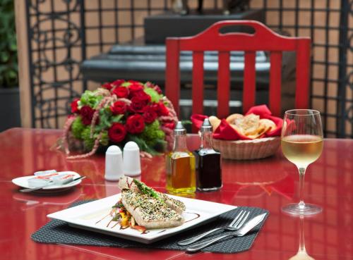 a table with a plate of food and a glass of wine at Hotel Geneve CD de Mexico in Mexico City