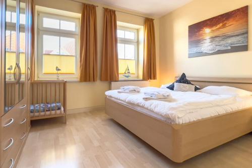 キュールングスボルンにあるHaus Finjaのベッドルーム1室(大型ベッド1台、窓2つ付)