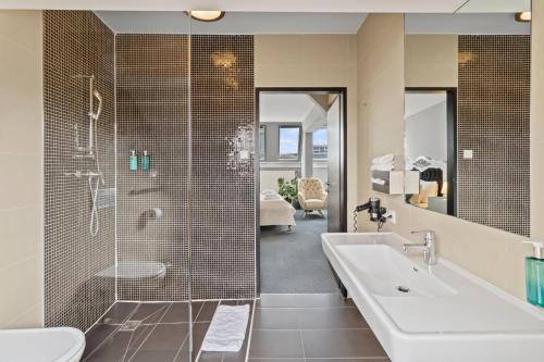 uma casa de banho com uma banheira, um chuveiro e um lavatório. em Hotel George Vienna em Viena