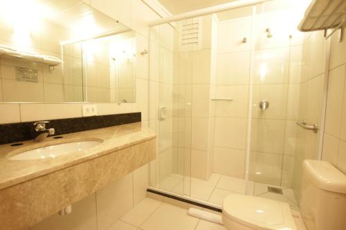 a bathroom with a shower and a sink and a toilet at Hotel Confiance Centro Cívico in Curitiba