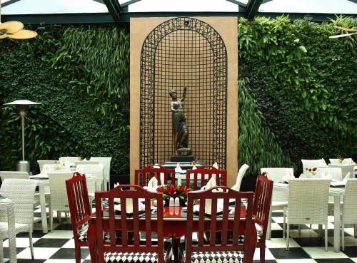 a restaurant with tables and chairs and a statue of a dog at Hotel Geneve CD de Mexico in Mexico City