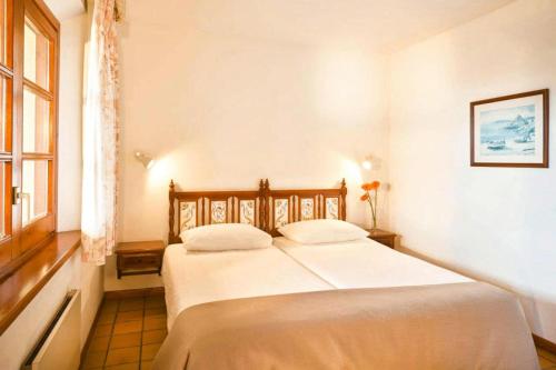 Schlafzimmer mit einem Bett mit weißer Bettwäsche und einem Fenster in der Unterkunft Hapimag Mas Nou holiday resort, Platja d'Aro in Platja  d'Aro