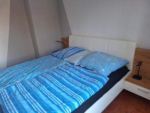 a bed with a blue comforter in a room at Nebenan in Soltau