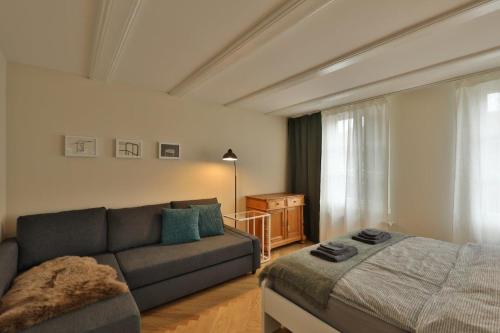 a living room with a couch and a bed at Union Apartments Bern-Belp in Belp