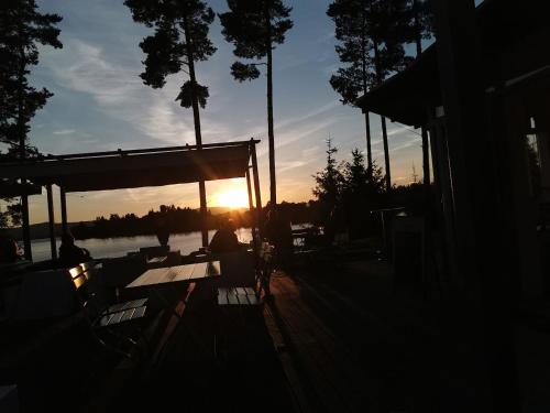 a sun setting over a dock with the sun setting at Deluxe Apartment Lipno - Lake Side Village, Frymburk nad Vltavou in Frymburk