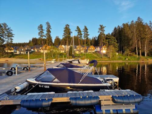 a small boat is docked at a dock at Deluxe Apartment Lipno - Lake Side Village, Frymburk nad Vltavou in Frymburk