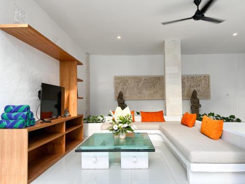 a living room with a couch and a tv at Apple Villas & Apartments in Kerobokan