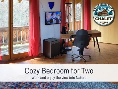 escritorio y silla en una habitación con ventana en Chalet Weyarn: Doppelzimmer mit Balkon, en Weyarn