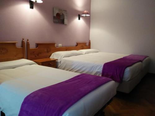 two beds in a room with purple blankets on them at San telmo in Tui