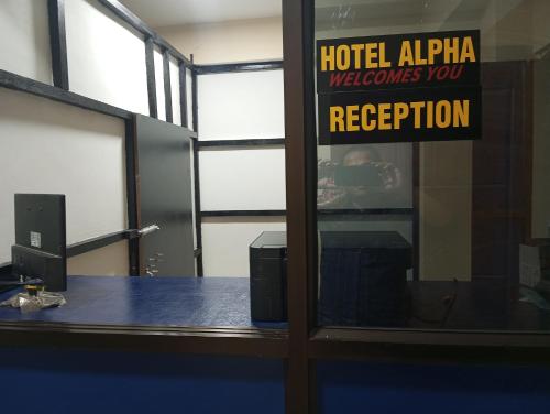 uma porta de escritório com uma placa que lê Hotel Alpha recebe-o na recepção em ALPHA Hotel em Imphal