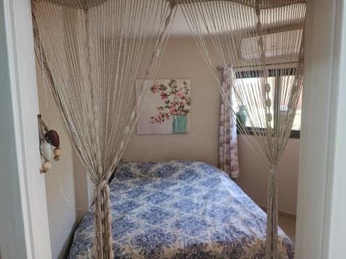 a bedroom with a bed with a canopy and curtains at Red Sea Garden Apartment in Eilat