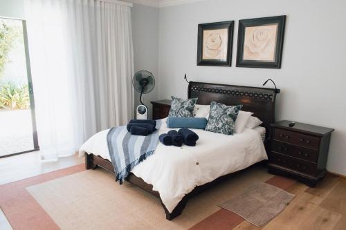 a bedroom with a bed with a black headboard at Tranquil Private Rooms Hermanus in Hermanus
