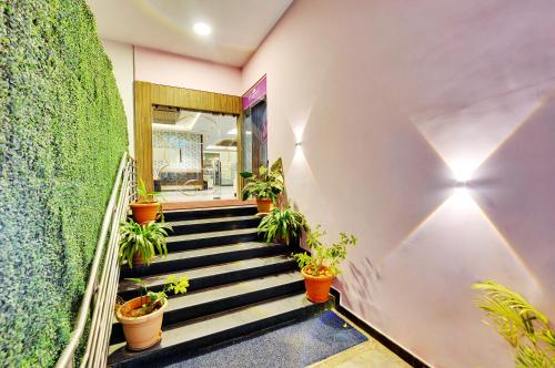 a staircase with potted plants in a building at Inaara Hotel, Bangalore in Bangalore