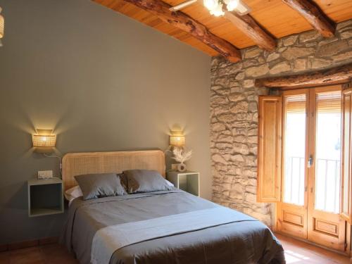 een slaapkamer met een bed en een stenen muur bij Modern Mansion in Guimera with Private Pool in Guimerá