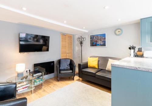 a living room with a couch and a tv at Inviting Traditional Fishermens cottage in the heart of the village, close to the harbour in Mevagissey
