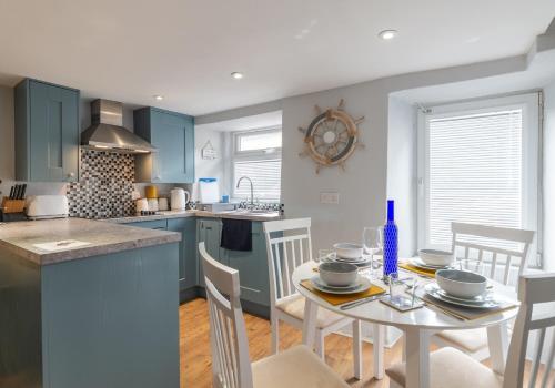 a kitchen and dining room with a table and chairs at Inviting Traditional Fishermens cottage in the heart of the village, close to the harbour in Mevagissey