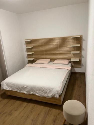 1 dormitorio con 1 cama con cabecero de madera en Appartement Cormondrèche, en Neuchâtel
